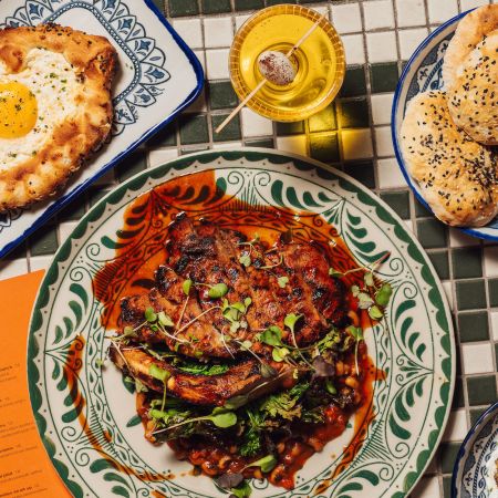 grilled meat, georgian bread and pita on a white and green tiled table
