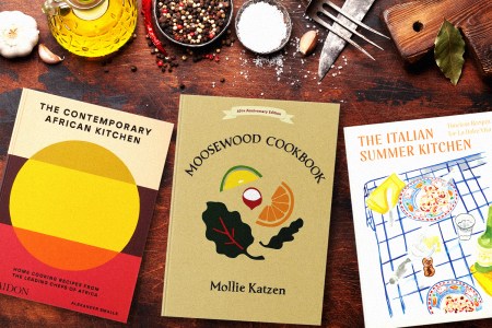 cookbooks on a kitchen table with tools and ingredients