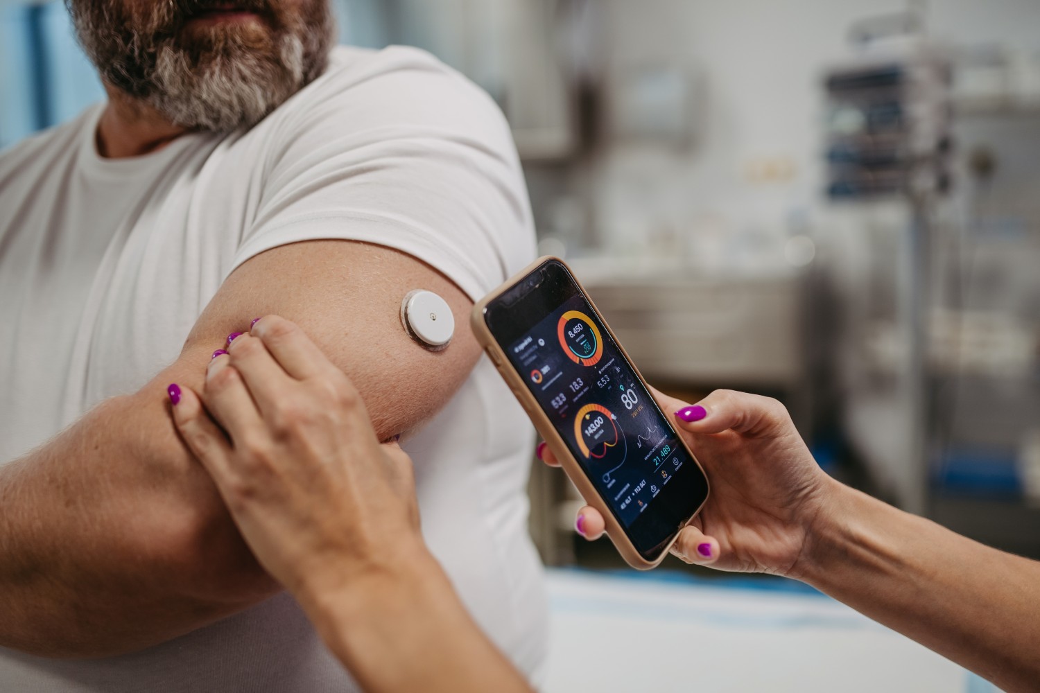 Medical professional monitoring a bearded man's glucose levels