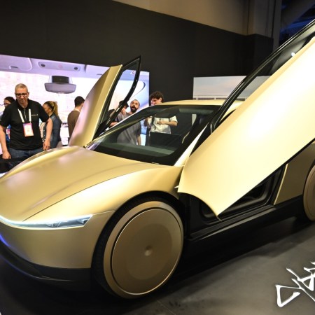 A golden Tesla robotaxi with the doors open