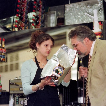 Christina Gibbs, left, of Saginaw, Michigan, holds up the brand of coffee she was using to make espresso, as Paul Songer, one of the judges, sniffs the beans, during the Torani 5th Annual Barista Cup, Saturday, May 1, 1999
