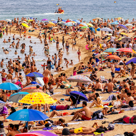 Tourists crowd a beach in Barcelona