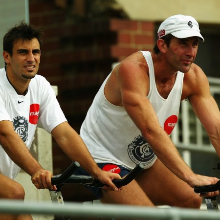 A pair of rugby players on exercise bikes.