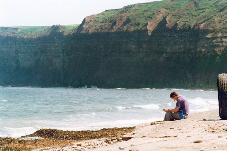 A man taking in the air at Saltburn Beach.