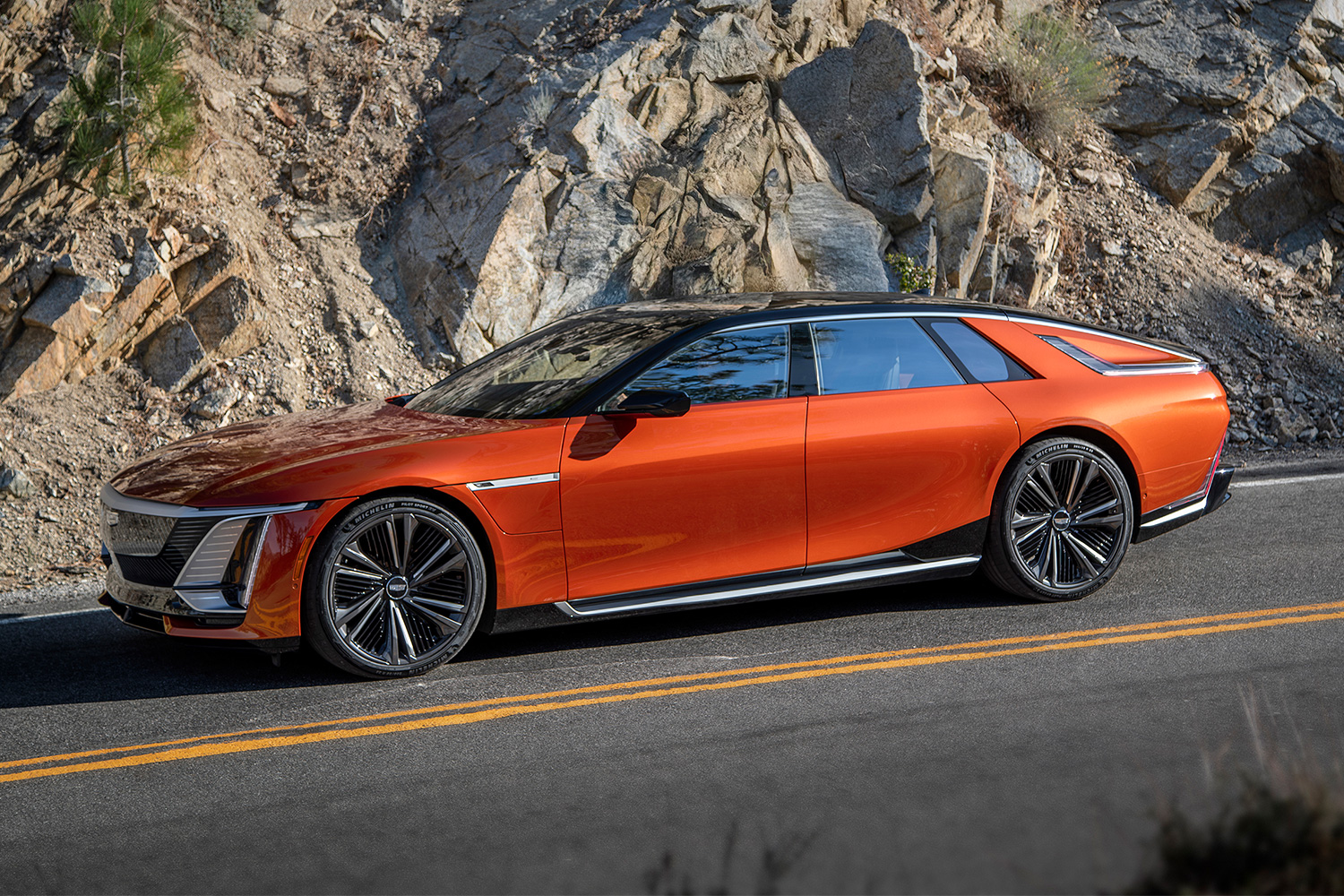 The electric Cadillac Celestiq in orange seen driving down a mountain road