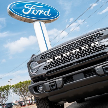 Ford Bronco parked under a Ford sign