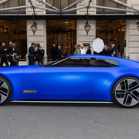 The Jaguar Type 00 concept car in blue sitting next to a curb during Paris Fashion Week
