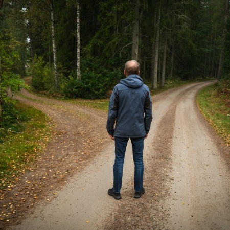 Man standing at a crossroads in the woods