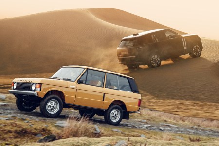 A Range Rover Classic driving to the left with a new electric Range Rover driving in the background