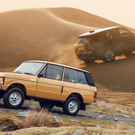 A Range Rover Classic driving to the left with a new electric Range Rover driving in the background