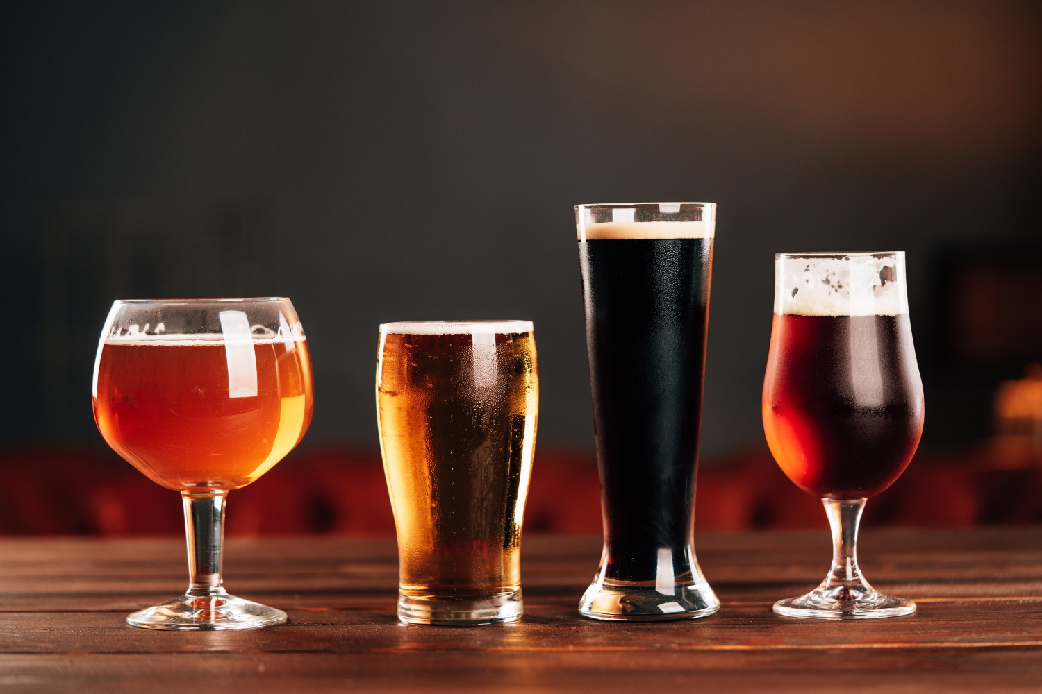 Four glasses holding different styles of beer