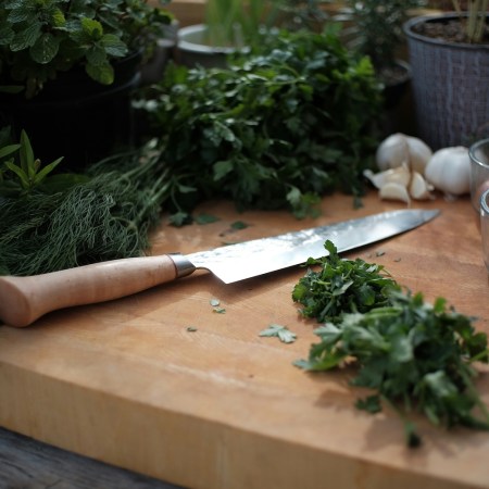 A knife on a cutting board next to different types of greens. We look at ways to get more fiber into your diet.