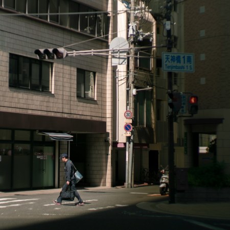 A Japanese man walking down the street.