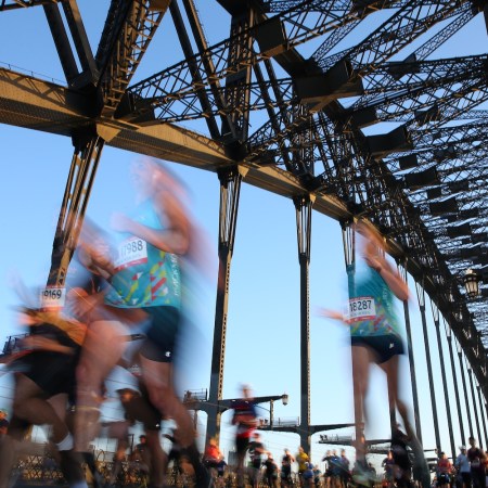 A photograph of blurry runners crossing a bridge.