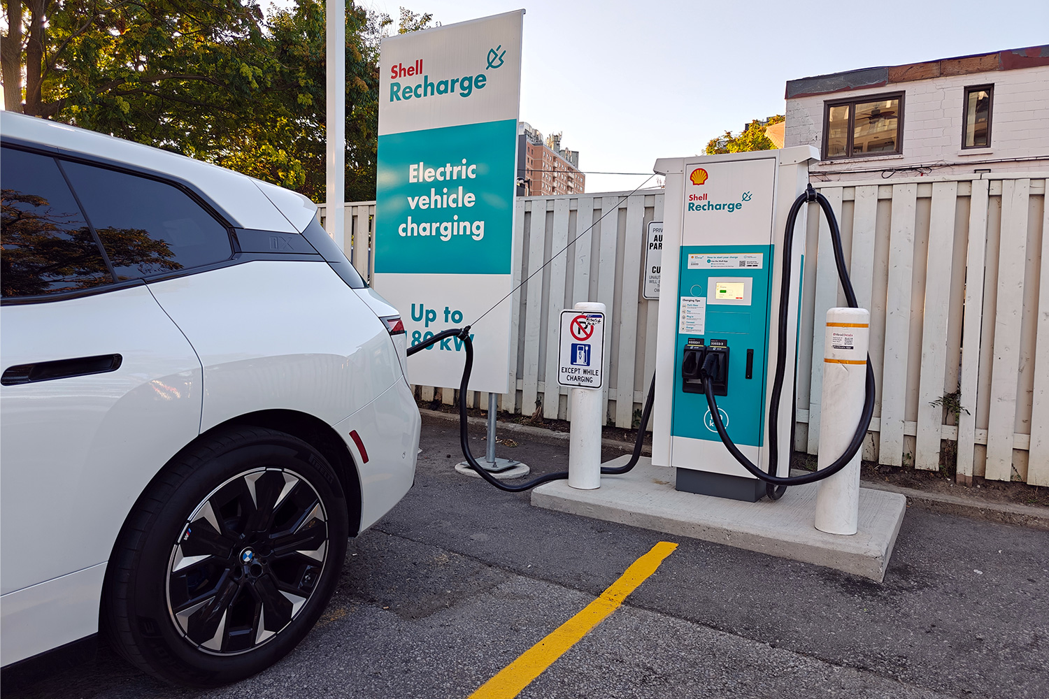 A Shell Recharge station with an EV plugged into it during a road trip
