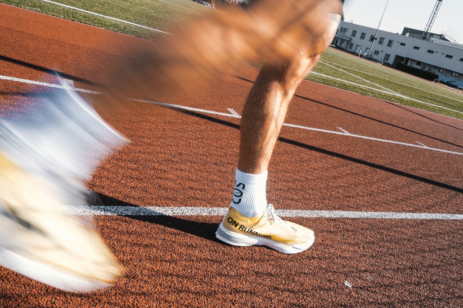 A pair of legs running quickly around a track.