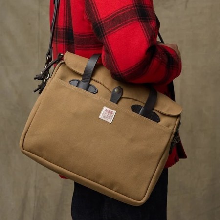 a man wearing a red flannel and holding a tan Filson briefcase