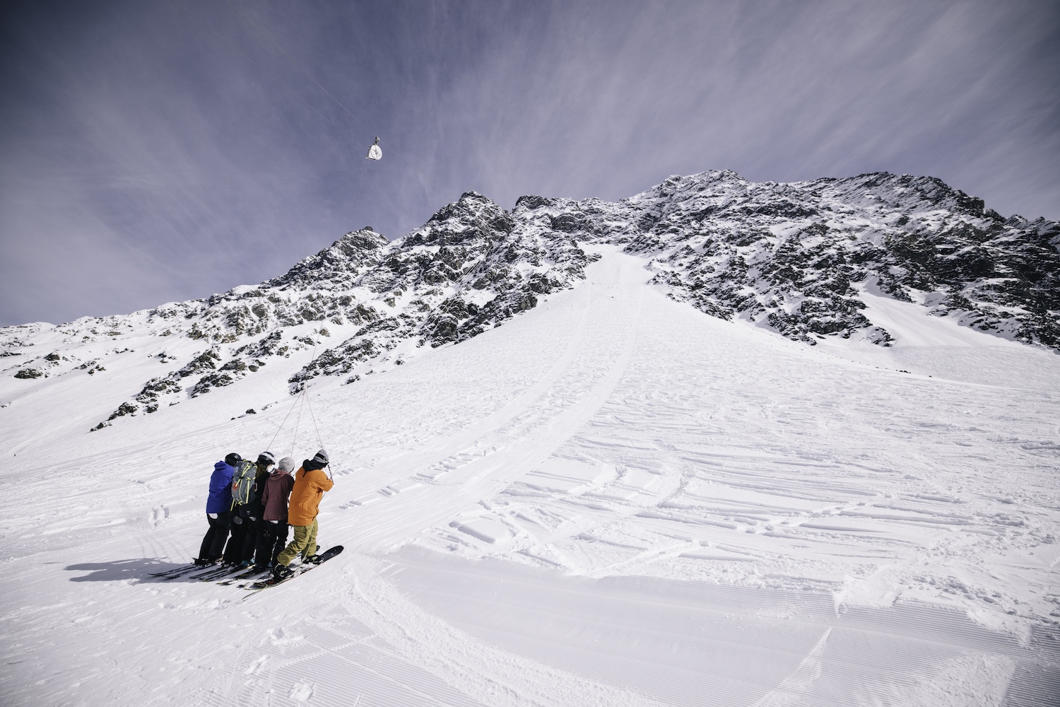 Four skiers hold onto the slingshot lift for dear life.
