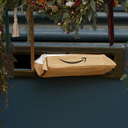 An Amazon package sticking out of a mail slot