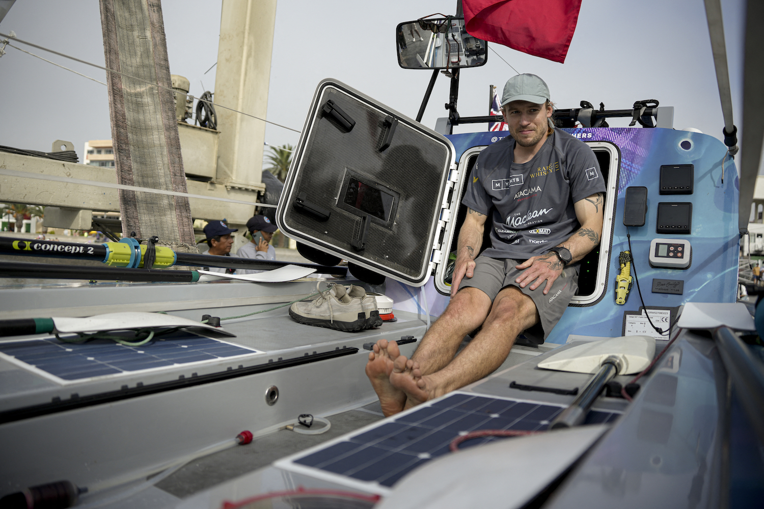 A man sits in an ocean row boat. 