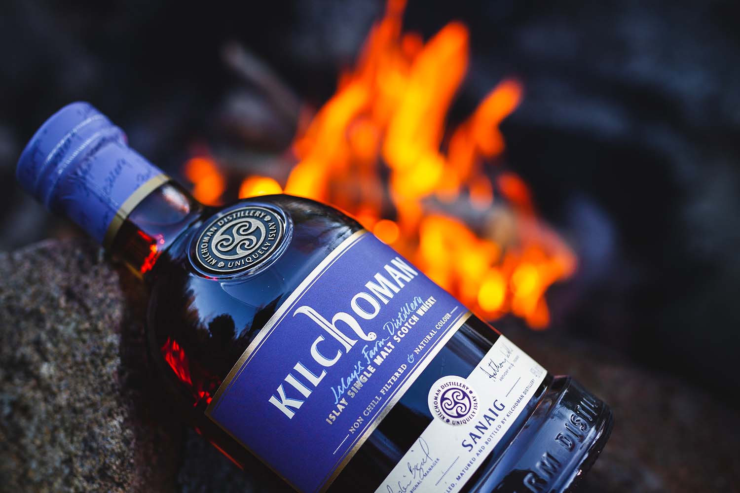 Kilchoman Sanaig bottle in front of a fire