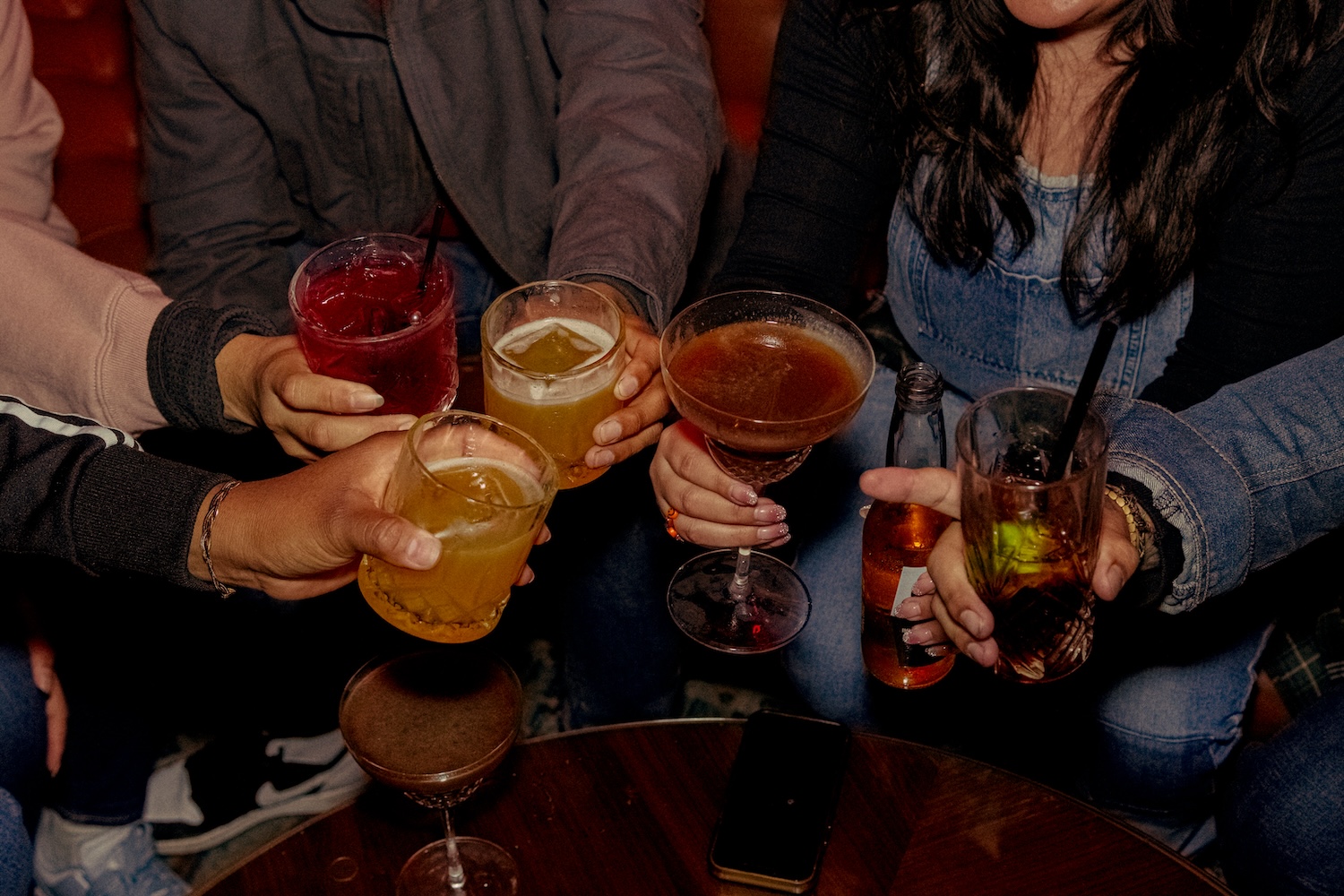 People holding cocktails together