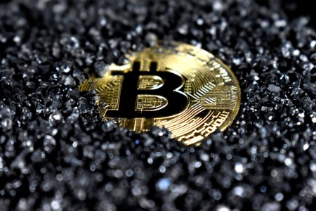 Bitcoin coin amidst gravel