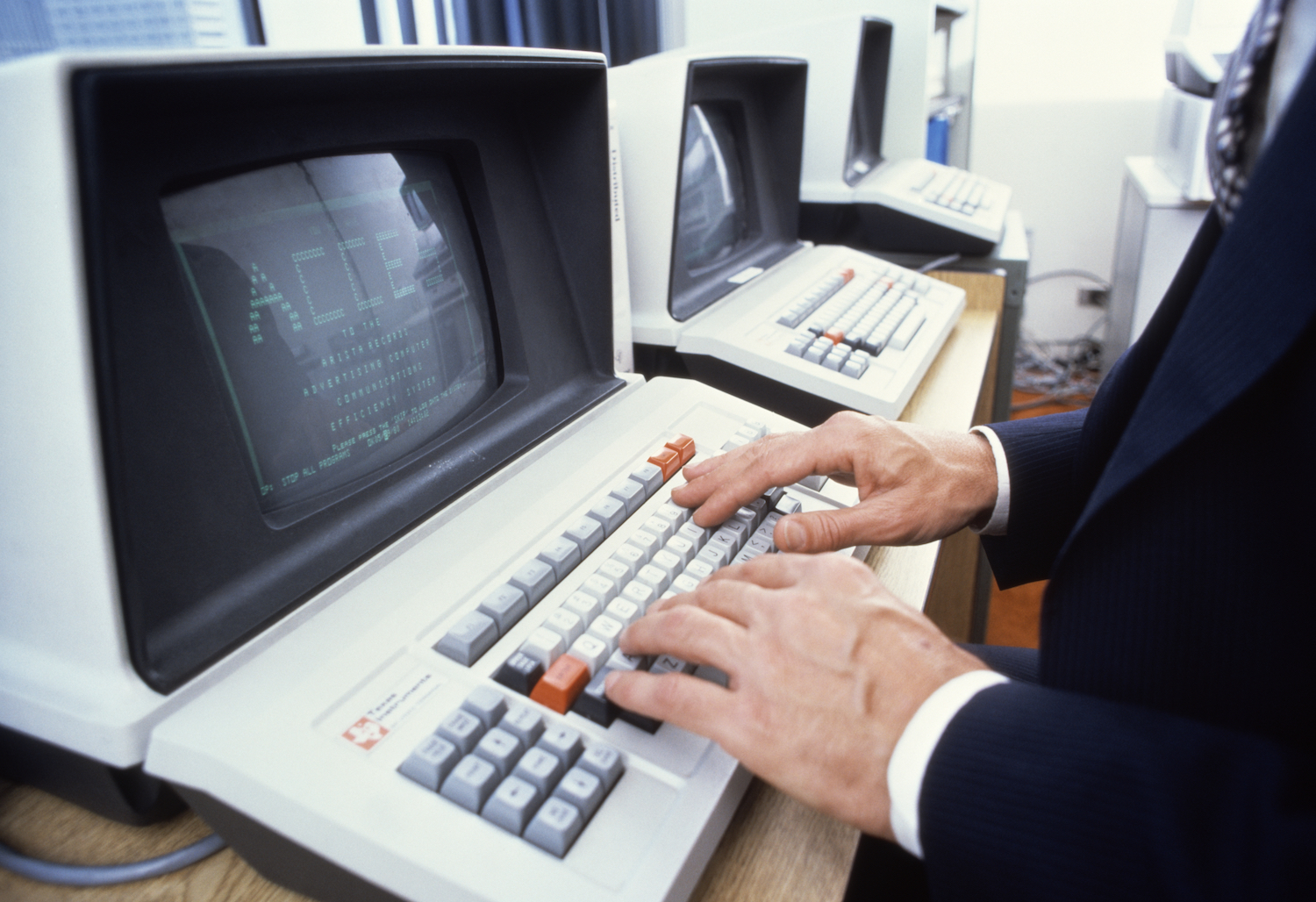 A man typing on an old keyboard.