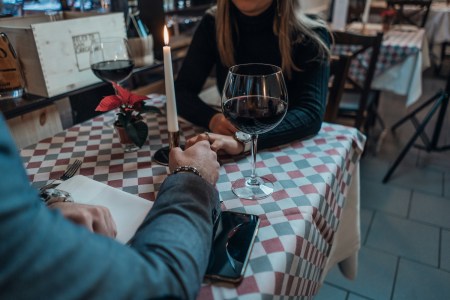 A couple holding hands over a table while on a date