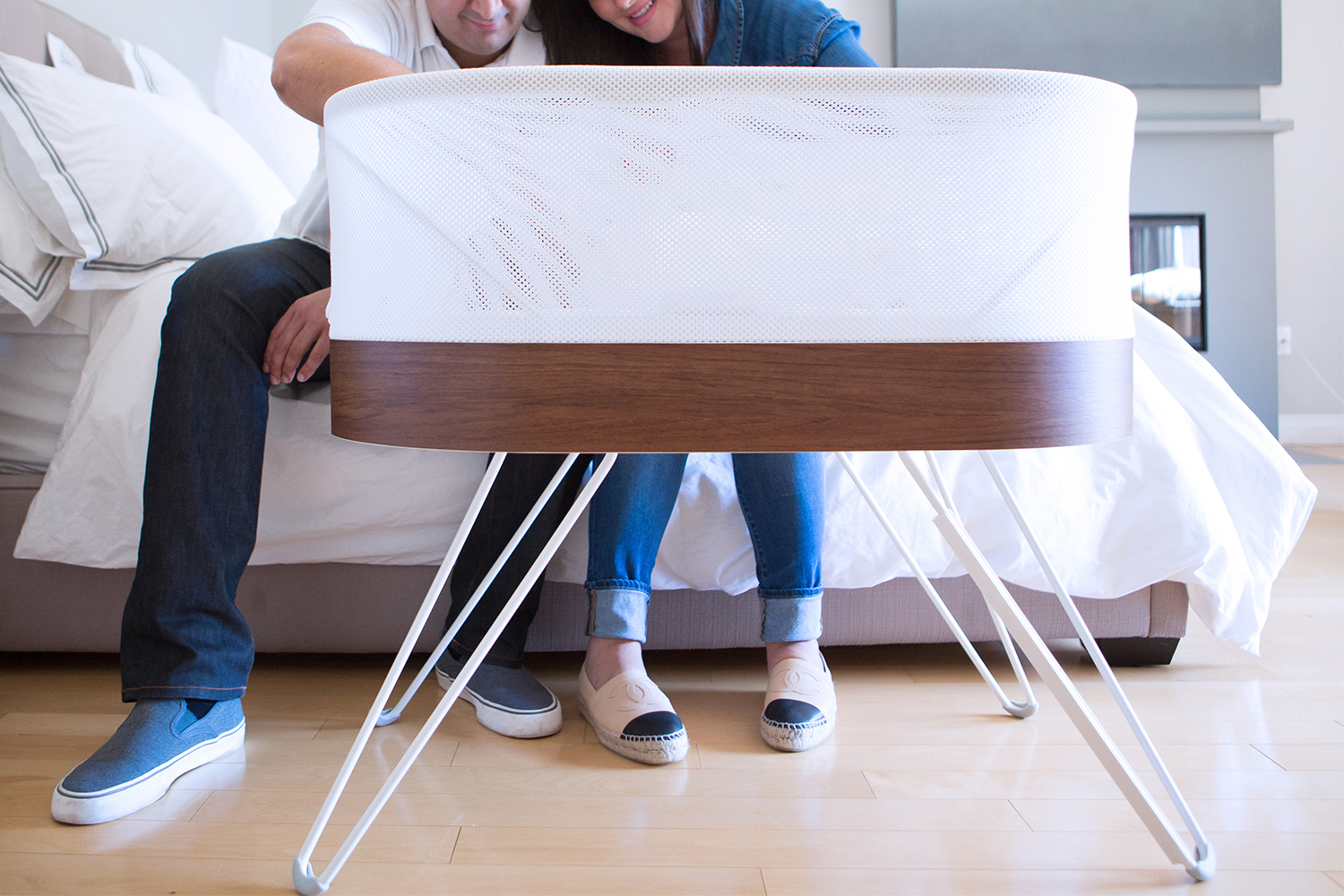 The Snoo from Happiest Baby, with two parents looking into the high-tech baby bassinet