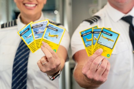 Two Spirit Airlines pilots holding up new trading cards featuring their various Airbus airplanes
