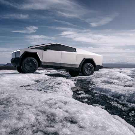 The electric Tesla Cybertruck driving across a frozen landscape