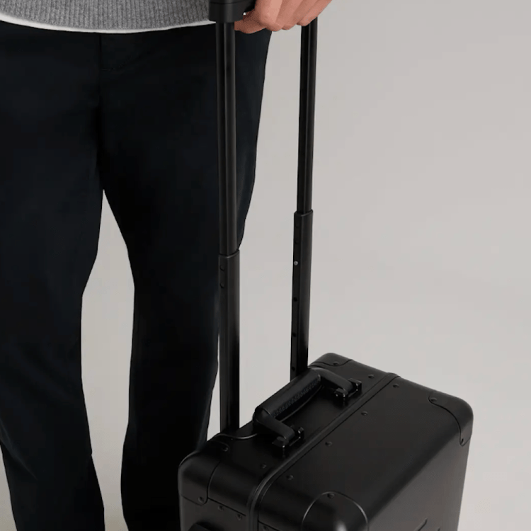 A model rolling a quince suitcase
