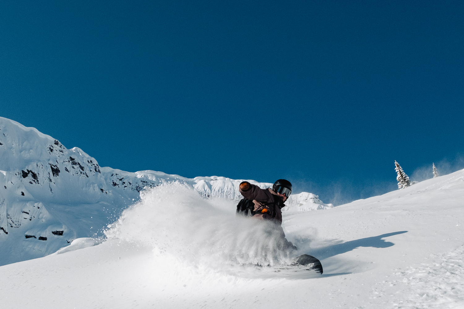 A man cutting into snow with snowboard.