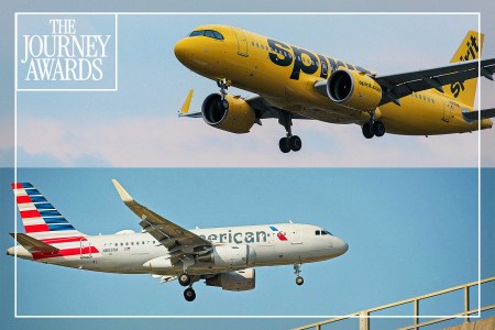 A Spirit Airlines plane and an American Airlines plane flying in the sky.