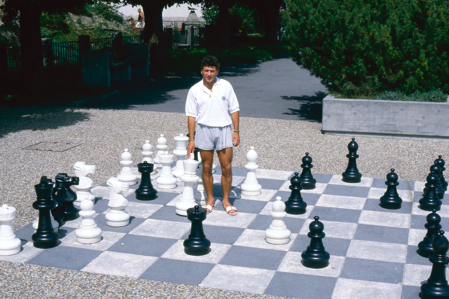 Man standing on a life-sized chessboard.