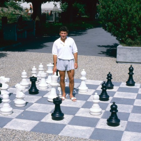 Man standing on a life-sized chessboard.