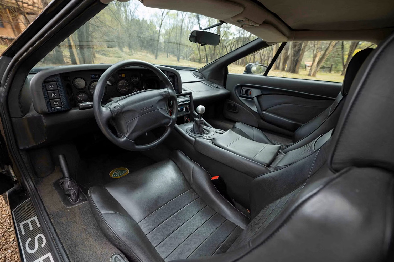 The interior of a car showing the steering wheel, stick shift and two front seats