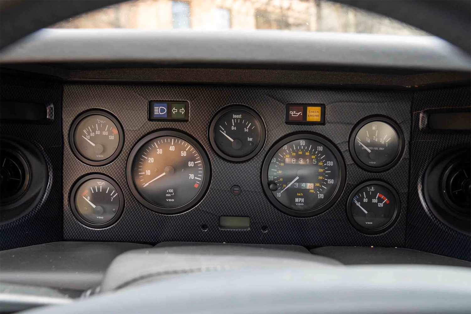 The dashboard of a car with odometer tachometer and other gauges