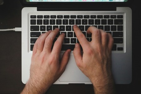 Hands typing on a laptop keyboard