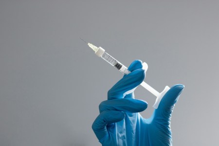 Hand in surgical glove holding needle