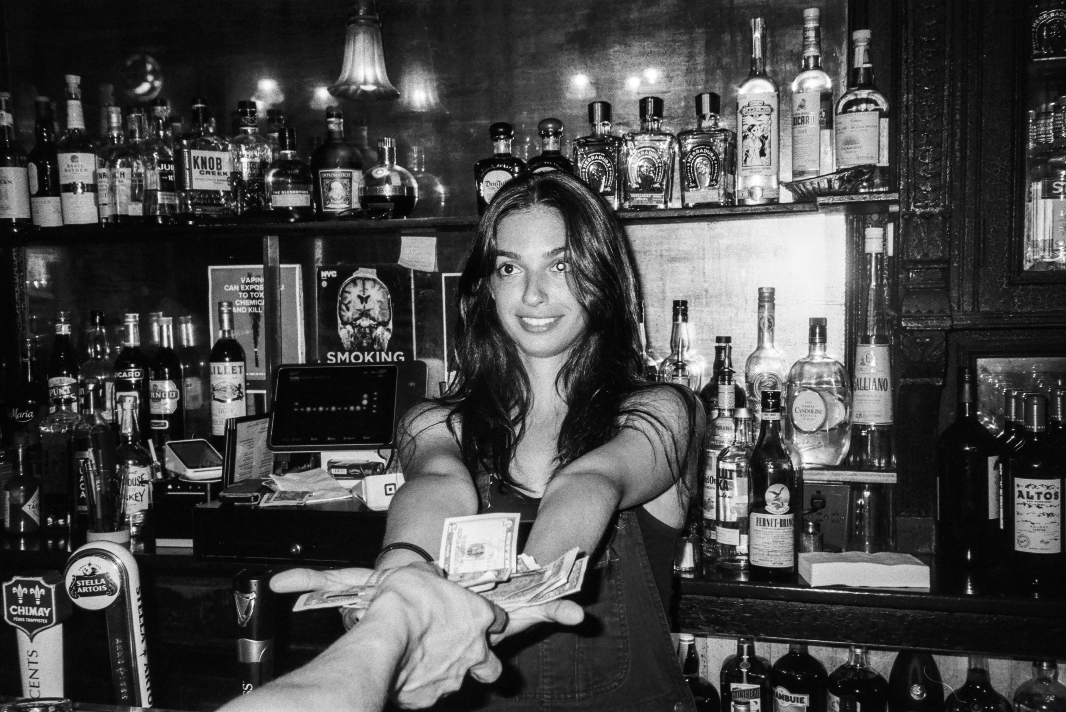 A woman standing behind a bar