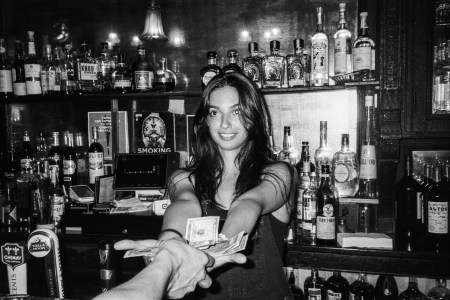 A woman standing behind a bar