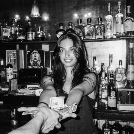 A woman standing behind a bar