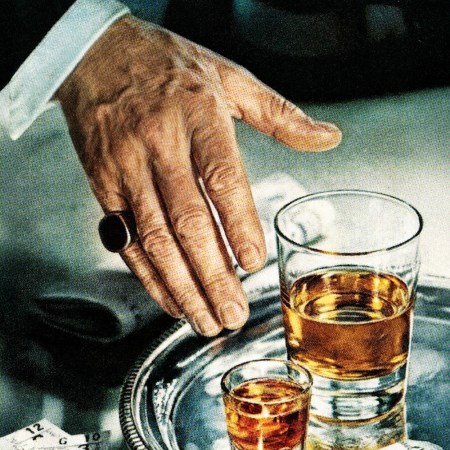 A man reaching for a glass of whiskey