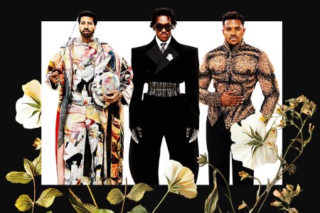 Three men in elaborate designer clothes standing in front of a white background surrounded by a black border with flowers growing up from the bottom