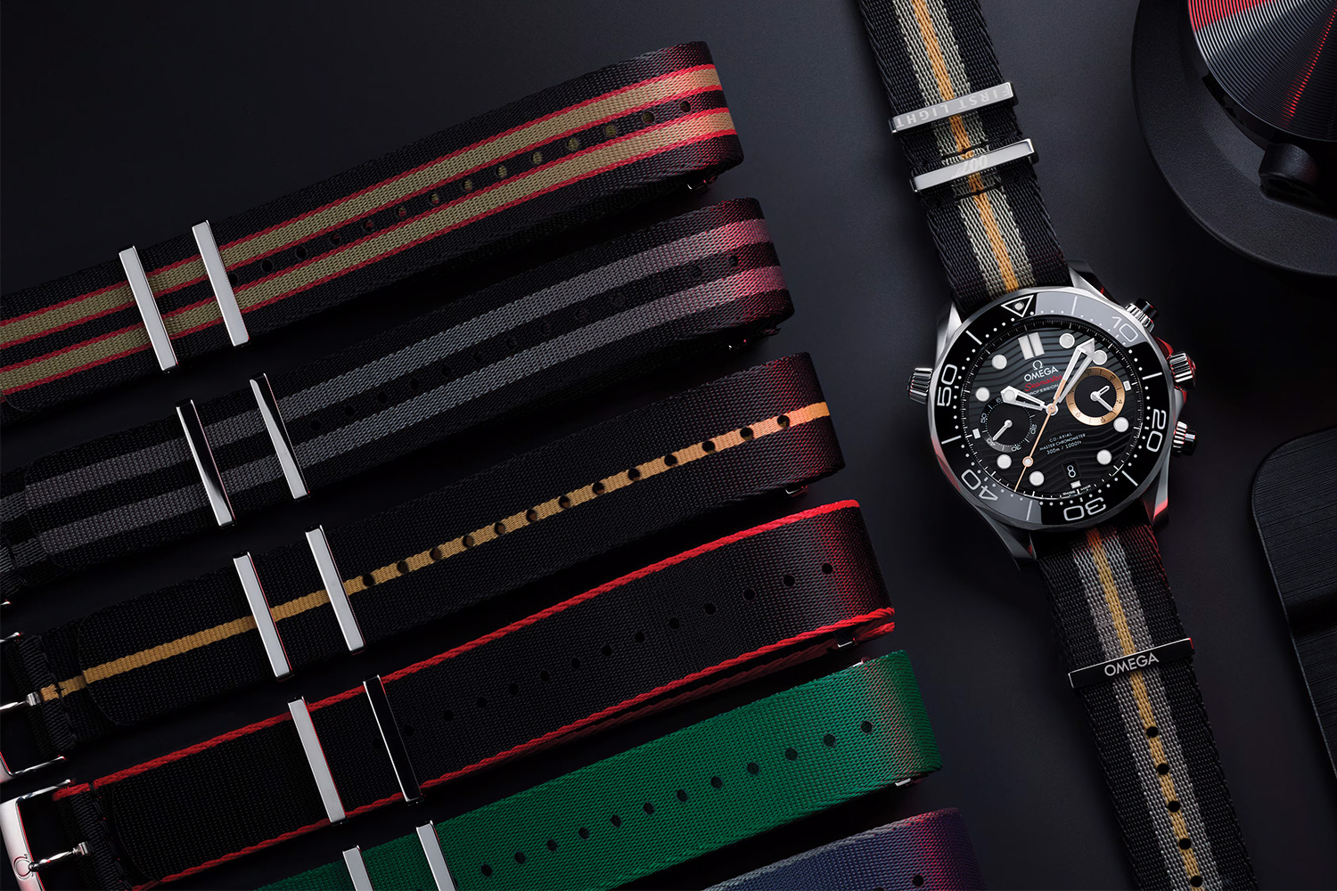 Six NATO watch straps sitting on a table next to a watch
