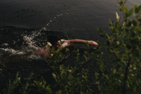A man swimming in a pond.