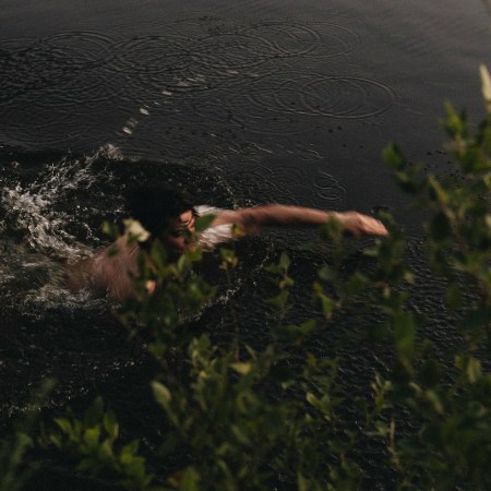 A man swimming in a pond.