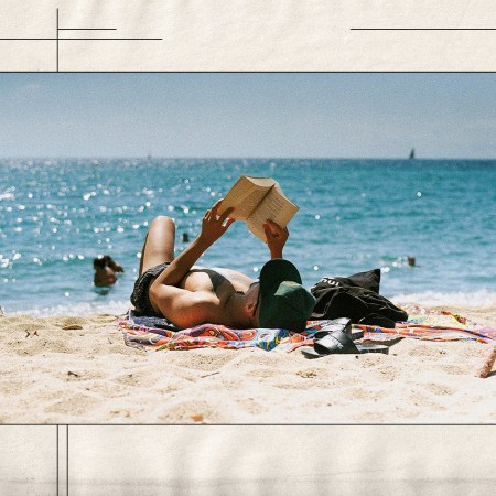 A man reading a book on the beach